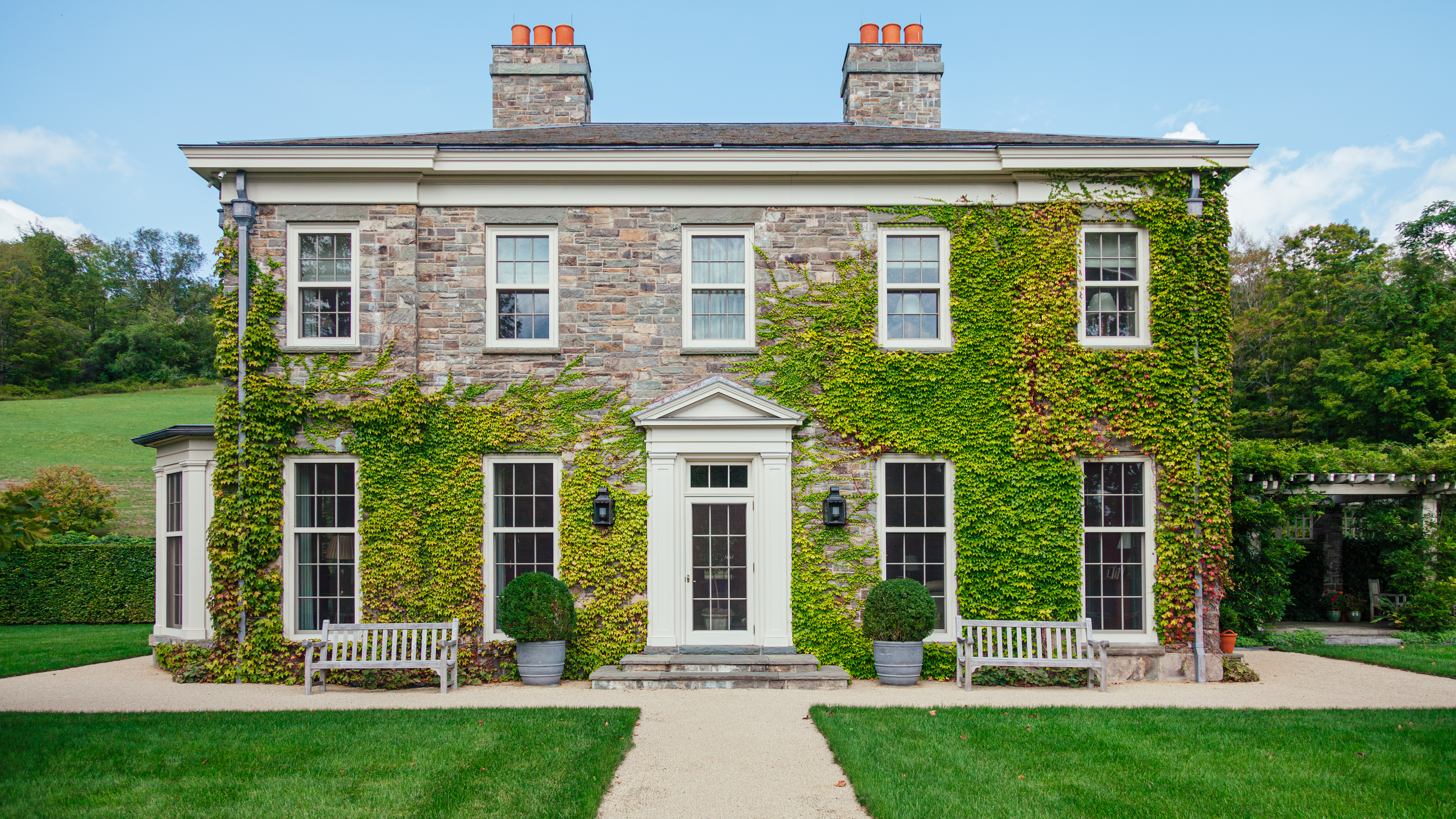 The Georgian-Palladian-style façade of a new house, designed by GP Schafer Architect, built above rolling farm fields in New York’s Hudson Valley.Photo credit: Brandon Mitchell for ICAA.